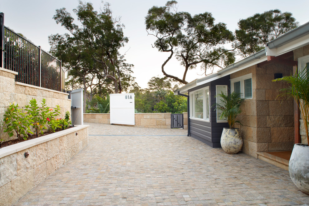 Large traditional front yard driveway in Sydney with natural stone pavers.