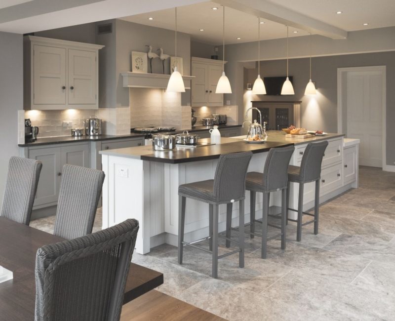 Large transitional u-shaped limestone floor and gray floor eat-in kitchen photo in Los Angeles with a farmhouse sink, recessed-panel cabinets, white cabinets, soapstone countertops, white backsplash, subway tile backsplash, stainless steel appliances, an island and gray countertops