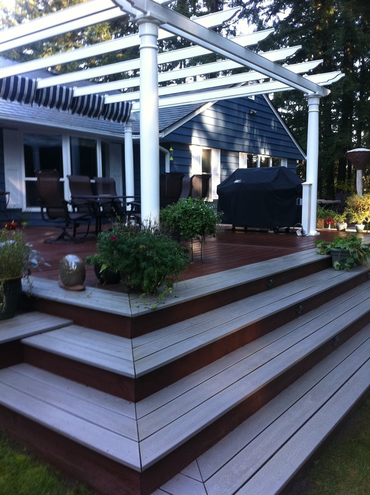 Transitional backyard deck in Seattle with a pergola.