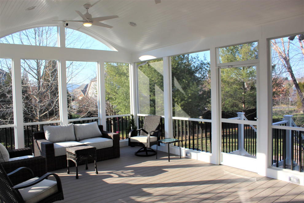 Inspiration for a large transitional backyard screened-in verandah in DC Metro with a roof extension and metal railing.