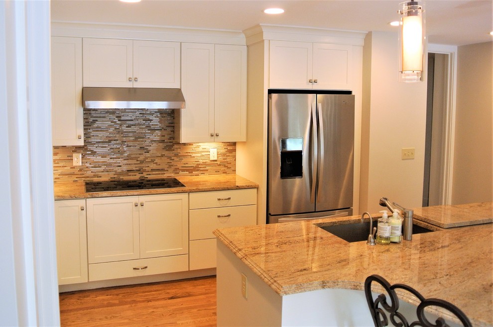 Inspiration for a transitional light wood floor kitchen remodel in Boston with an undermount sink, shaker cabinets, white cabinets, granite countertops, stainless steel appliances and an island