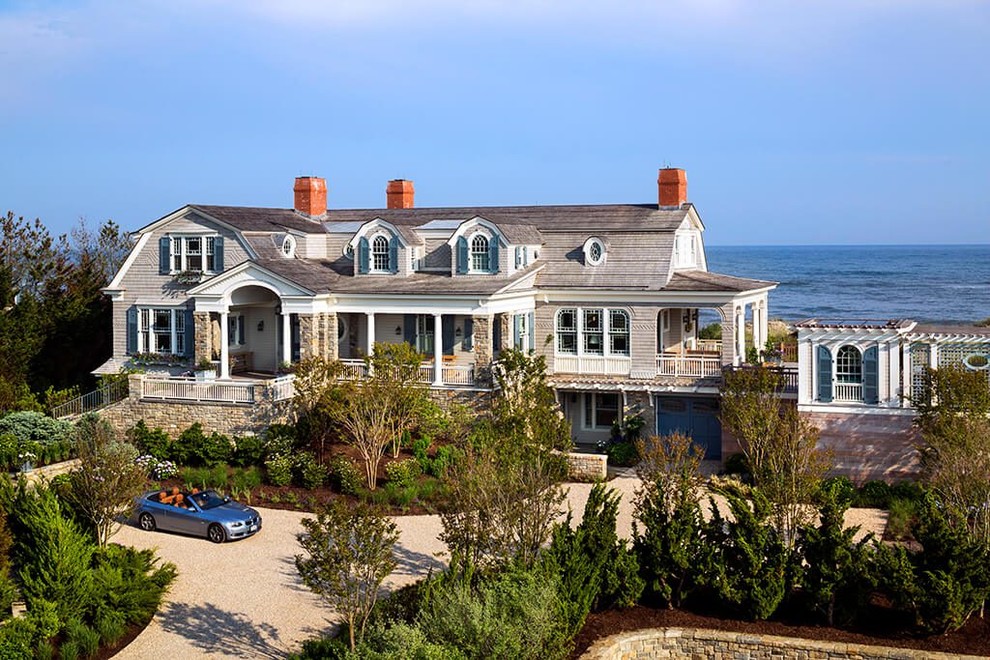 Beach style three-storey grey house exterior in Other with wood siding and a shingle roof.