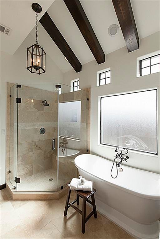 Inspiration for a large mediterranean master bathroom in Houston with a freestanding tub, an alcove shower, white walls and travertine floors.