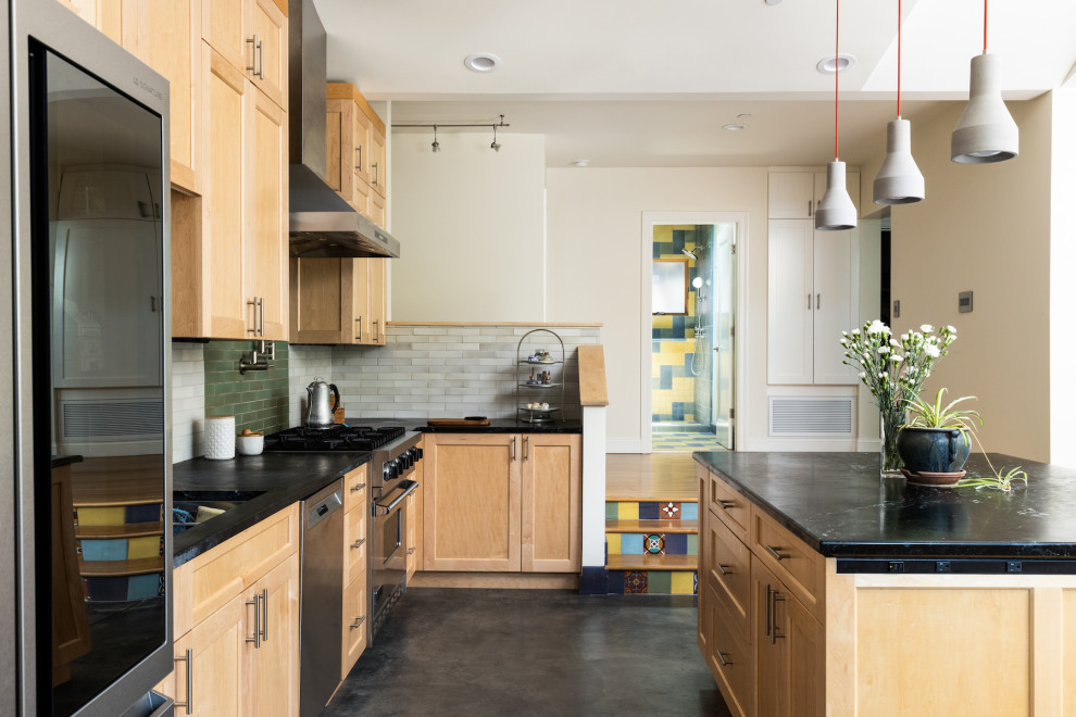Inspiration for an eclectic l-shaped concrete floor eat-in kitchen remodel in San Francisco with multicolored backsplash, an island and black countertops
