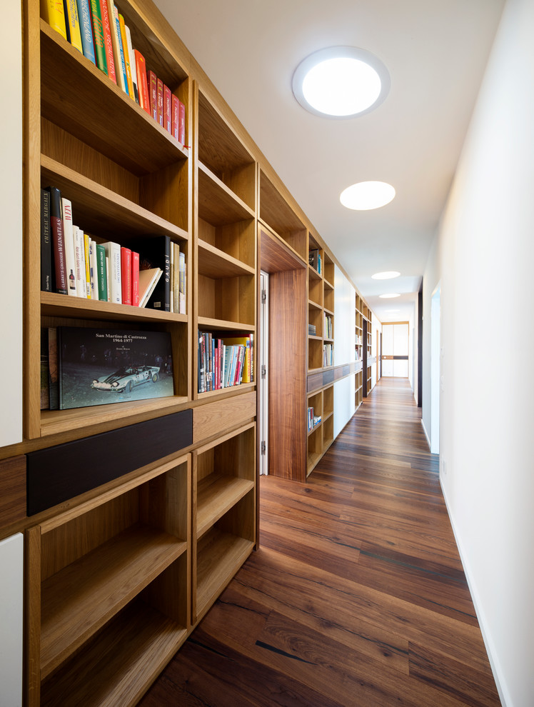 Inspiration for an expansive midcentury hallway in Frankfurt with beige walls and dark hardwood floors.