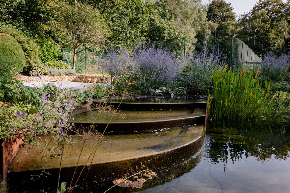 Geometrischer, Großer, Halbschattiger Landhausstil Gartenteich hinter dem Haus mit Natursteinplatten in Surrey