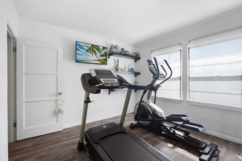 Mid-sized tuscan medium tone wood floor and multicolored floor multiuse home gym photo in Los Angeles with white walls