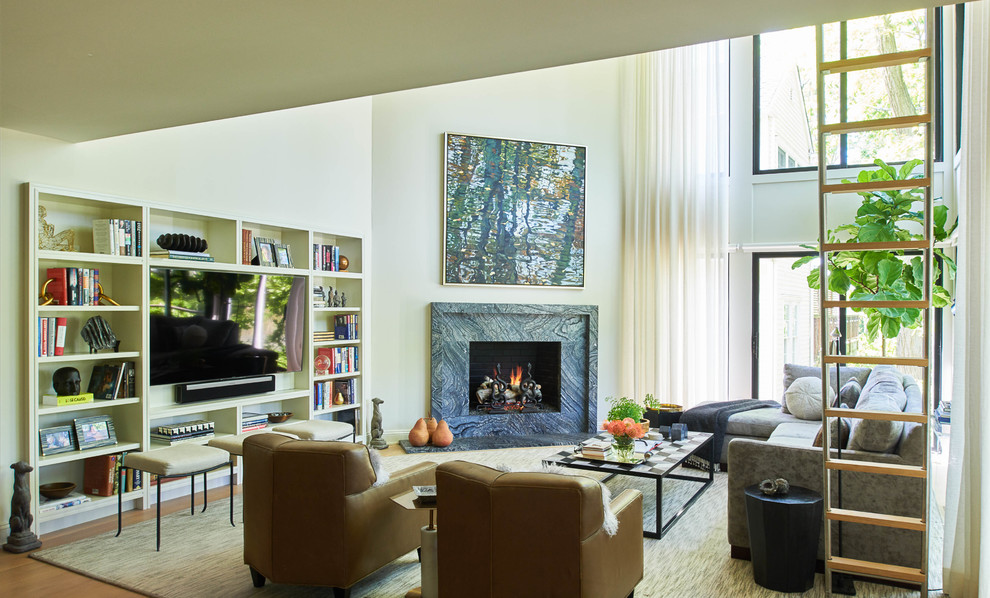 This is an example of a contemporary open concept living room in New York with beige walls, medium hardwood floors, a standard fireplace, a stone fireplace surround and brown floor.