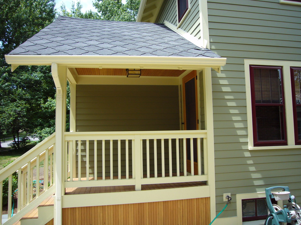 Photo of a mid-sized traditional front yard verandah in Detroit with a roof extension.
