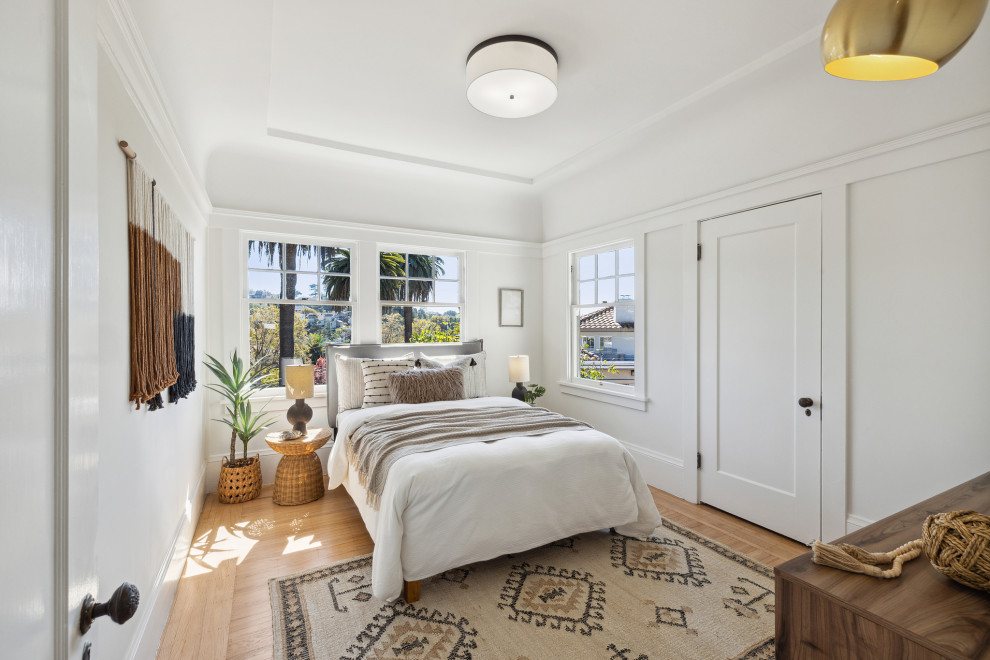 Inspiration for a small transitional guest bedroom in San Francisco with white walls, light hardwood floors, beige floor and coffered.