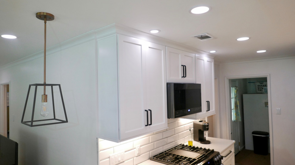 Mid-sized transitional galley porcelain tile and gray floor eat-in kitchen photo with an undermount sink, shaker cabinets, white cabinets, quartz countertops, white backsplash, subway tile backsplash, black appliances, no island and white countertops