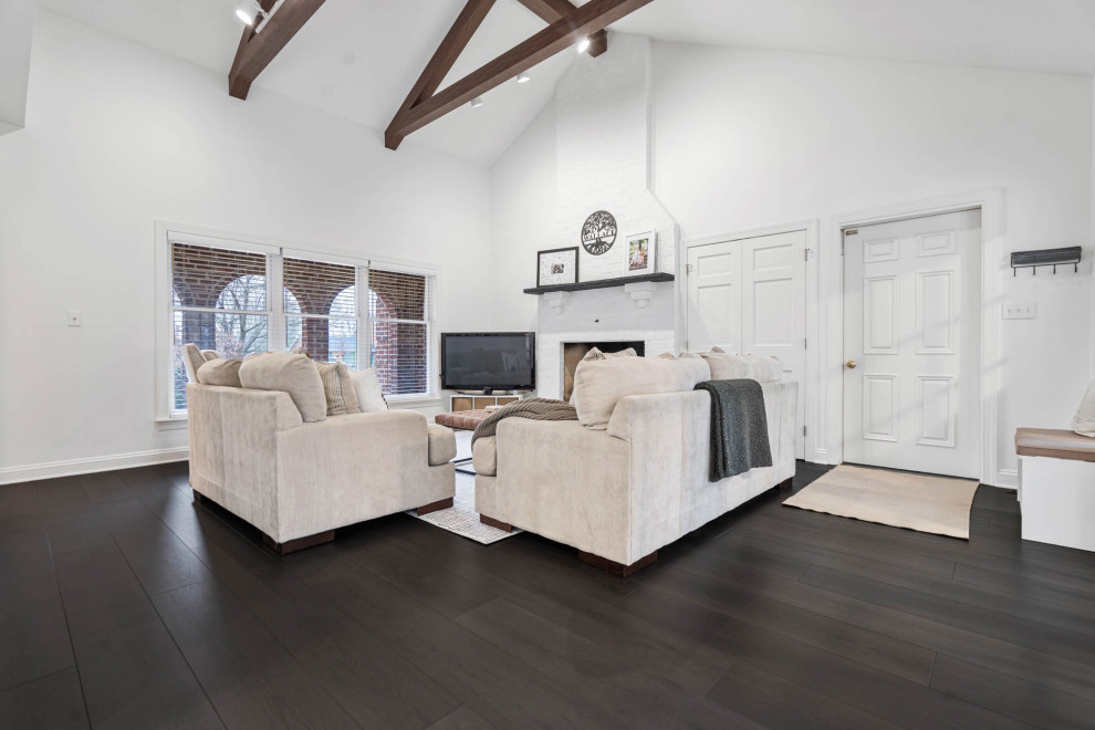 Mid-sized minimalist formal and open concept vinyl floor, brown floor and vaulted ceiling living room photo in DC Metro with white walls, a standard fireplace, a brick fireplace and a tv stand