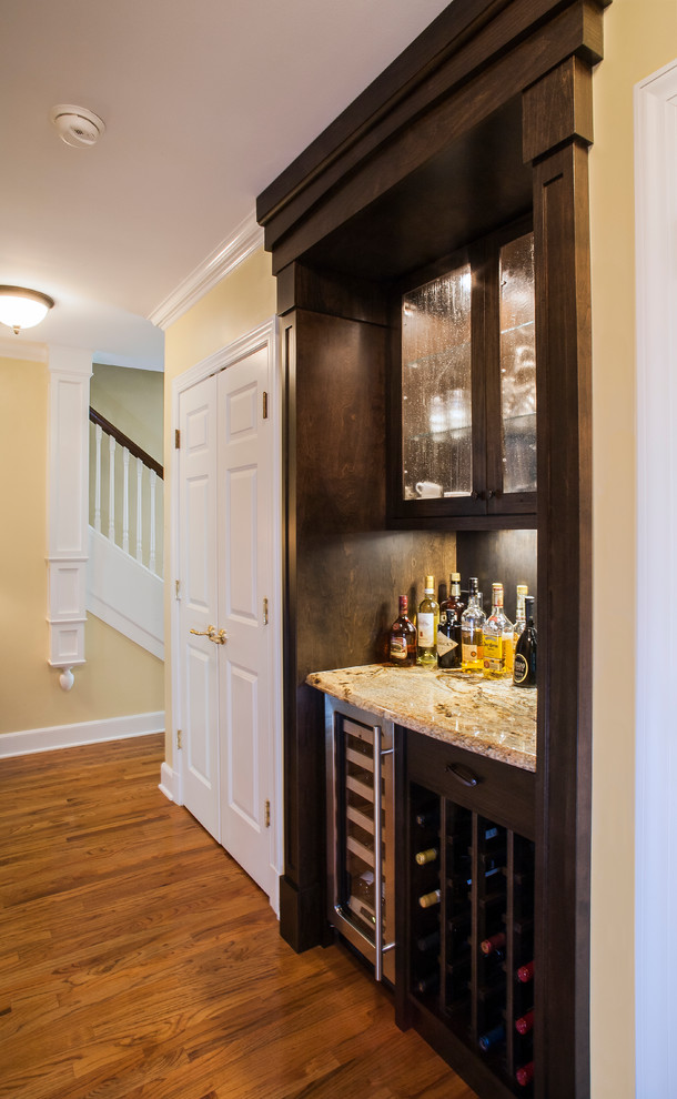 Design ideas for a small traditional single-wall home bar in Other with glass-front cabinets, dark wood cabinets, granite benchtops and medium hardwood floors.