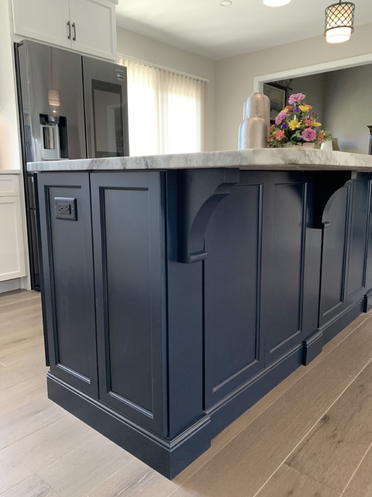 Large transitional l-shaped vinyl floor and gray floor eat-in kitchen photo with an undermount sink, recessed-panel cabinets, white cabinets, quartz countertops, gray backsplash, ceramic backsplash, stainless steel appliances, an island and white countertops