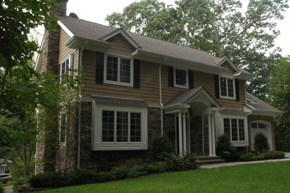 This is an example of a mid-sized traditional two-storey brown exterior in New York with vinyl siding and a gable roof.