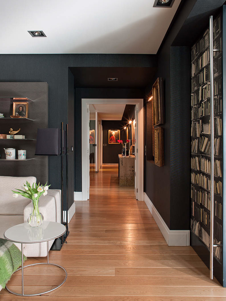 This is an example of a traditional hallway in Bilbao with black walls and medium hardwood floors.