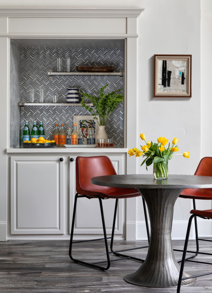 This is an example of a transitional seated home bar in Houston with no sink, raised-panel cabinets, white cabinets, multi-coloured splashback, mosaic tile splashback, medium hardwood floors, grey floor and white benchtop.
