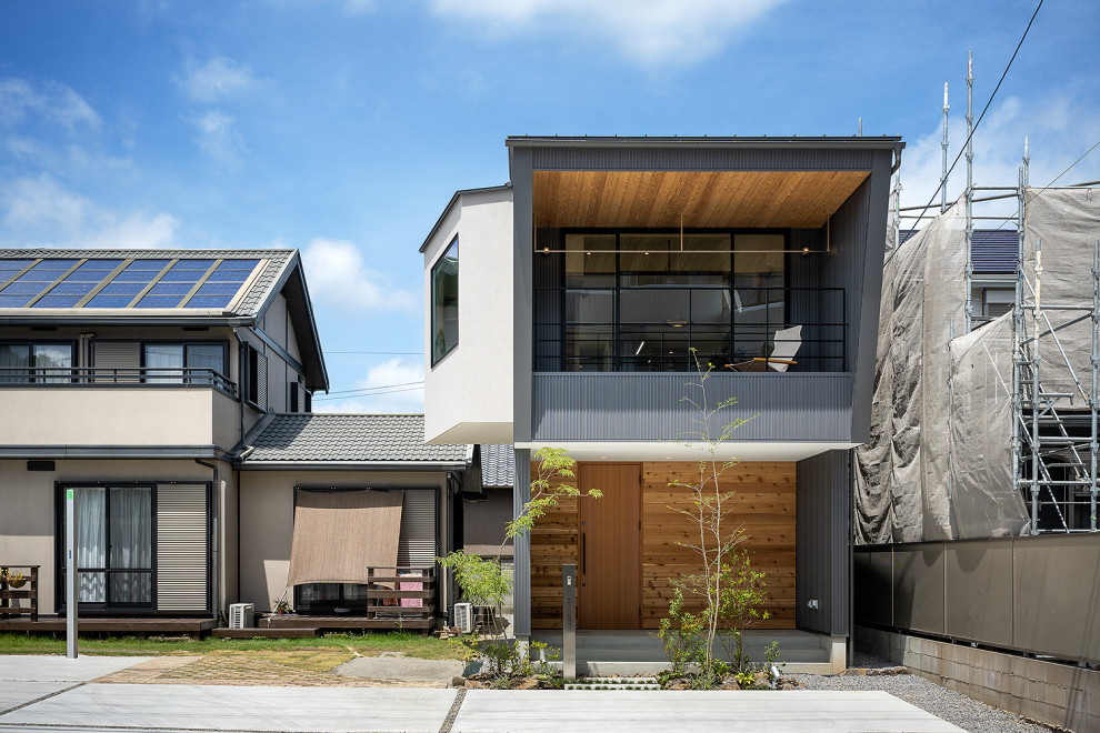 Foto de fachada de casa gris y gris nórdica pequeña de dos plantas con tejado de un solo tendido, tejado de metal, revestimiento de metal y panel y listón