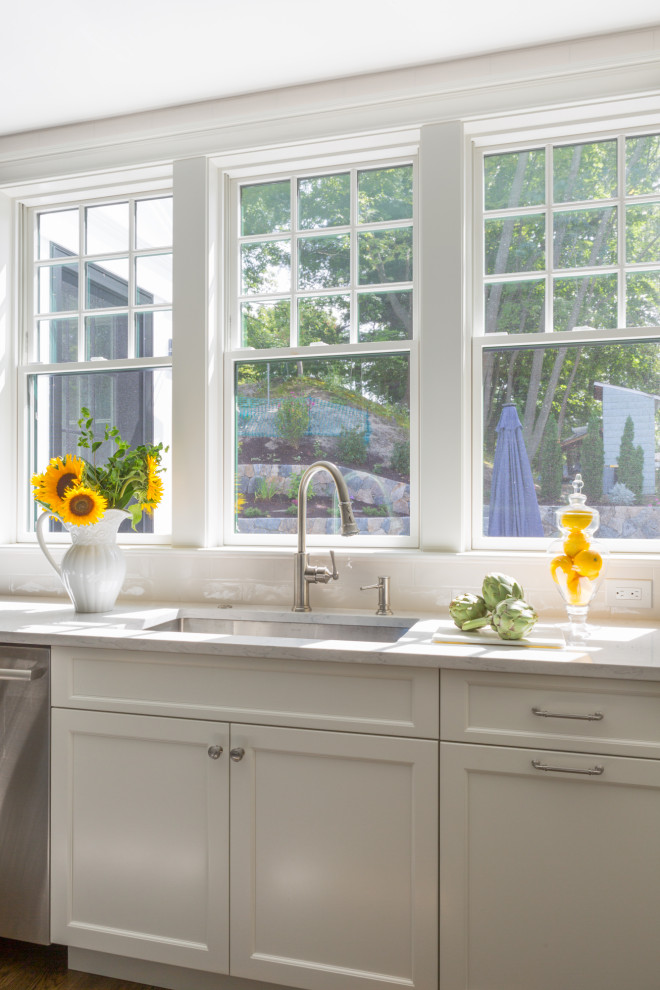 Large transitional u-shaped dark wood floor and brown floor open concept kitchen photo in Boston with an undermount sink, shaker cabinets, white cabinets, quartzite countertops, white backsplash, ceramic backsplash, stainless steel appliances, an island and white countertops