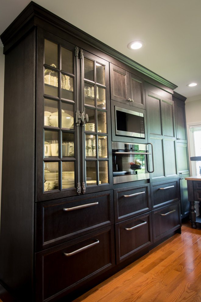 Inspiration for a large rustic l-shaped light wood floor and brown floor eat-in kitchen remodel with an undermount sink, recessed-panel cabinets, dark wood cabinets, quartz countertops, white backsplash, stainless steel appliances, an island, white countertops and quartz backsplash