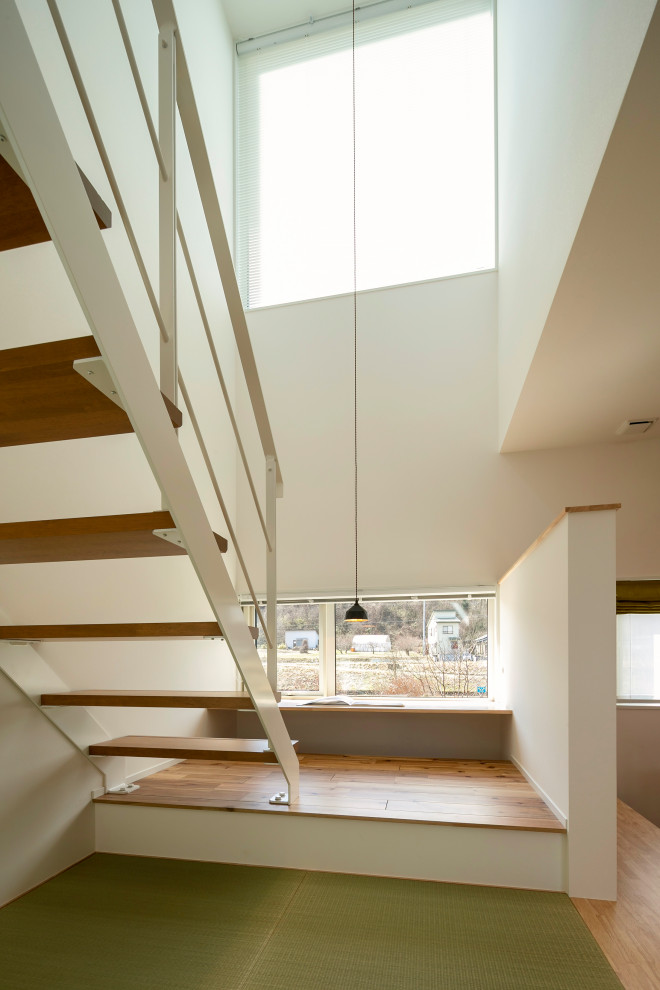 Exemple d'un escalier sans contremarche flottant tendance de taille moyenne avec des marches en bois, un garde-corps en métal, du papier peint et éclairage.