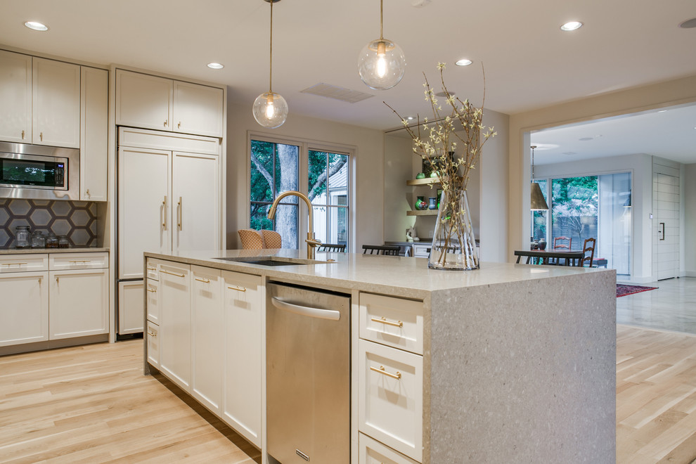 Inspiration for a large transitional kitchen in Dallas with quartz benchtops, beige splashback, cement tile splashback, white appliances, light hardwood floors and with island.