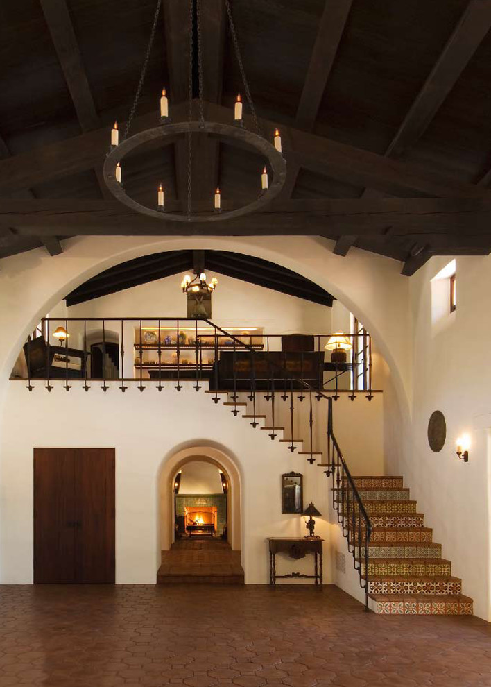 Design ideas for a mediterranean terracotta staircase in Los Angeles with tile risers and metal railing.