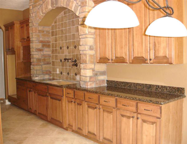 Eat-in kitchen - large transitional u-shaped porcelain tile and beige floor eat-in kitchen idea in Houston with a double-bowl sink, raised-panel cabinets, medium tone wood cabinets, granite countertops, beige backsplash, travertine backsplash and an island