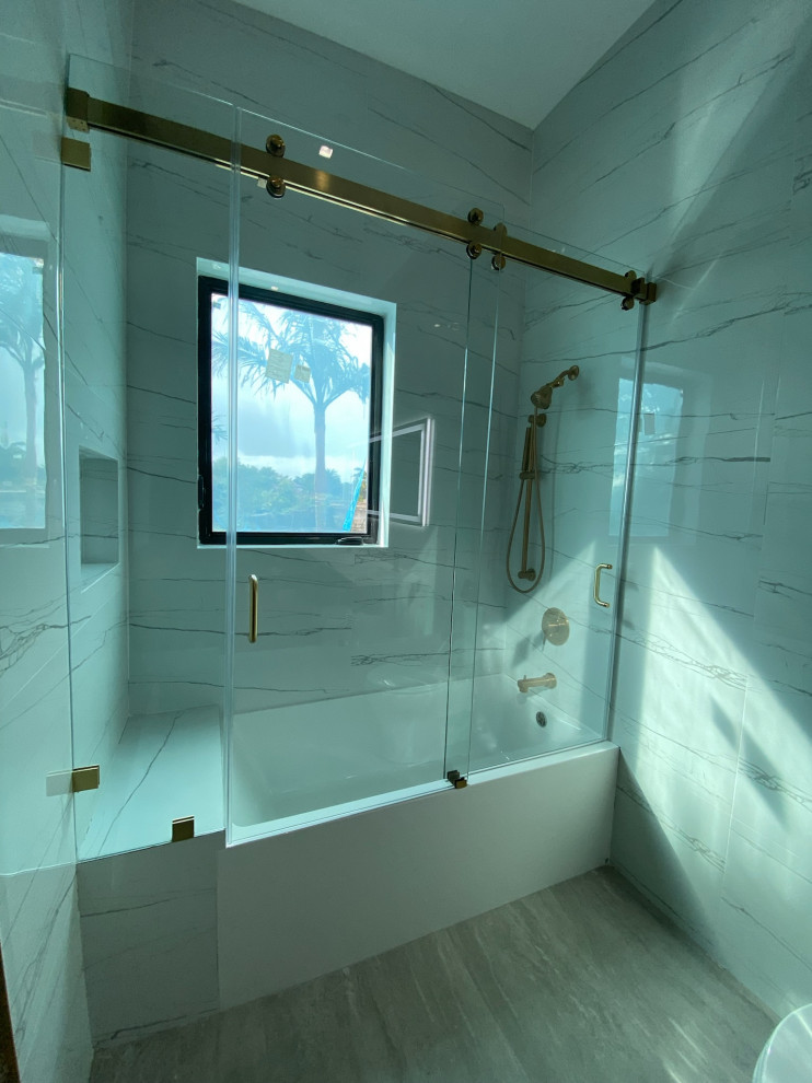Idéer för att renovera ett mellanstort funkis vit vitt badrum med dusch, med en dusch/badkar-kombination, släta luckor, ett badkar i en alkov, en toalettstol med hel cisternkåpa, flerfärgad kakel, marmorkakel, flerfärgade väggar, mosaikgolv, ett nedsänkt handfat, granitbänkskiva, flerfärgat golv och dusch med gångjärnsdörr