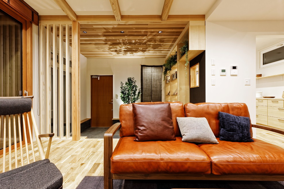 他の地域にある広いトラディショナルスタイルのおしゃれなLDK (白い壁、淡色無垢フローリング、暖炉なし、据え置き型テレビ、茶色い床) の写真