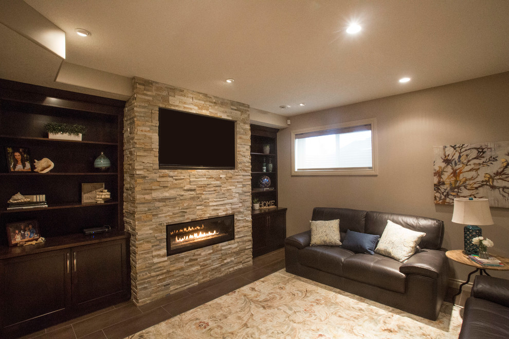 This is an example of a mid-sized transitional fully buried basement in Edmonton with green walls, concrete floors, a stone fireplace surround and a ribbon fireplace.