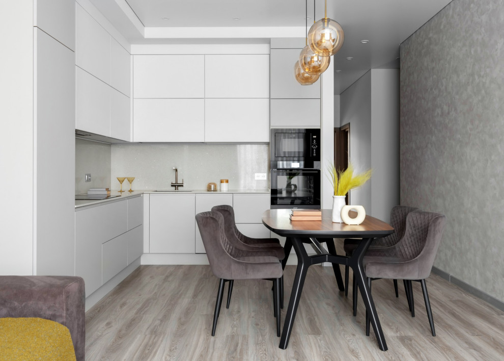 Design ideas for a mid-sized contemporary l-shaped eat-in kitchen in Other with an undermount sink, flat-panel cabinets, grey cabinets, quartz benchtops, grey splashback, engineered quartz splashback, black appliances, vinyl floors, no island, brown floor and grey benchtop.