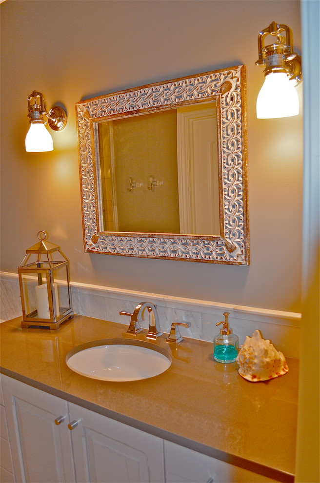 Example of a mountain style white tile marble floor bathroom design in Omaha with an undermount sink and solid surface countertops