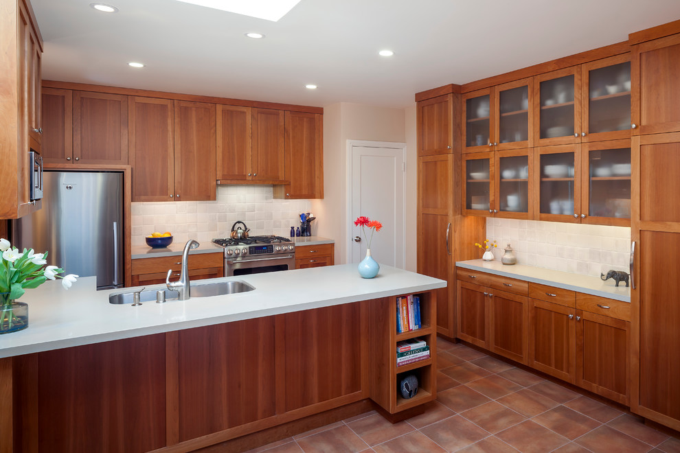 Transitional u-shaped kitchen in San Francisco with a double-bowl sink, shaker cabinets, medium wood cabinets, beige splashback, stone tile splashback and stainless steel appliances.