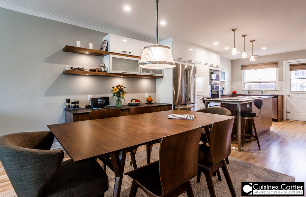 Eat-in kitchen - large transitional galley medium tone wood floor eat-in kitchen idea in Montreal with an undermount sink, flat-panel cabinets, dark wood cabinets, quartzite countertops, white backsplash, mosaic tile backsplash, stainless steel appliances and an island