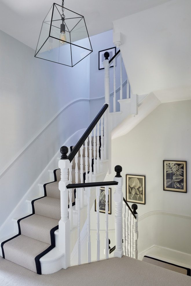 Imagen de escalera curva clásica renovada de tamaño medio con escalones de madera pintada, contrahuellas de madera pintada y barandilla de madera