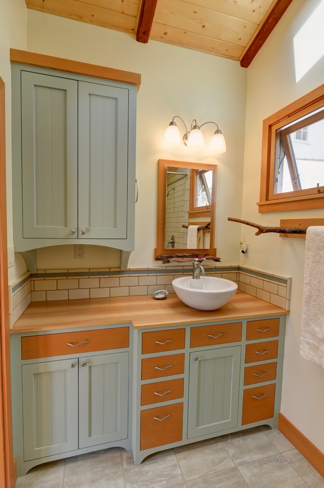 Small beach style 3/4 bathroom in San Diego with flat-panel cabinets, green cabinets, a corner shower, beige tile, ceramic tile, yellow walls, porcelain floors, a vessel sink, wood benchtops and a shower curtain.