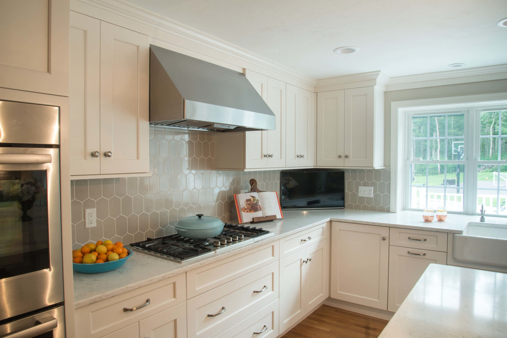 Eat-in kitchen - transitional l-shaped eat-in kitchen idea in Providence with a farmhouse sink, quartzite countertops, ceramic backsplash, stainless steel appliances and an island
