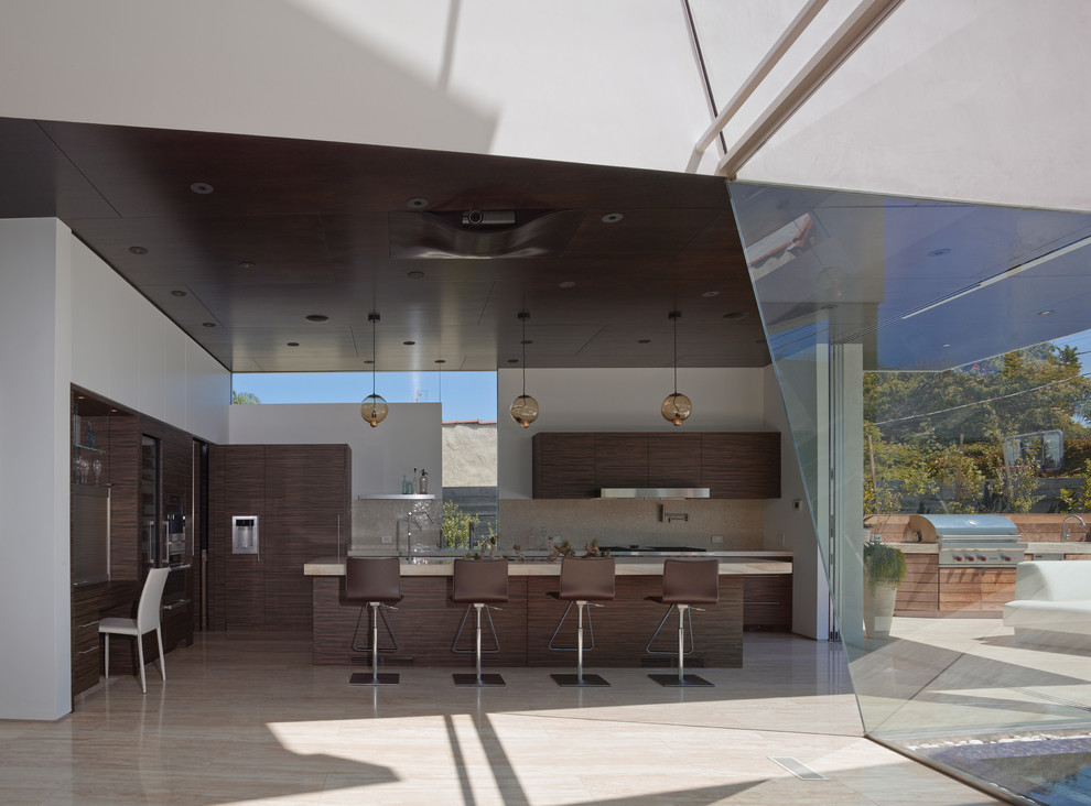 Design ideas for a mid-sized contemporary eat-in kitchen in Los Angeles with an integrated sink, flat-panel cabinets, dark wood cabinets, onyx benchtops, beige splashback, stone tile splashback, panelled appliances, travertine floors and with island.