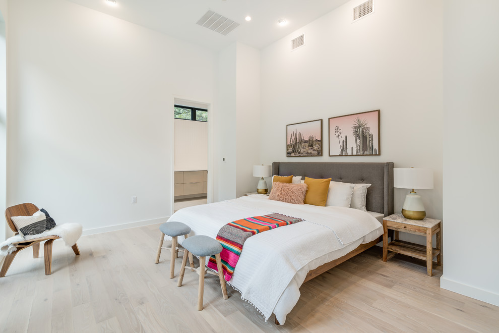 Photo of a mid-sized scandinavian master bedroom in Austin with white walls, light hardwood floors, no fireplace and beige floor.