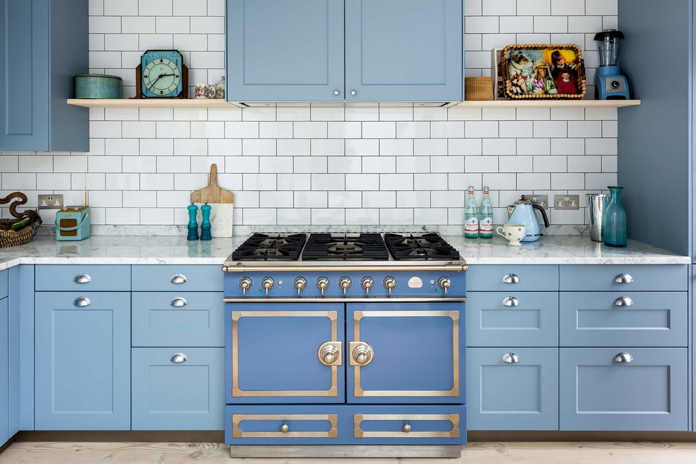 Inspiration for a traditional kitchen in London with shaker cabinets, blue cabinets, yellow splashback, subway tile splashback, coloured appliances, light hardwood floors and grey benchtop.