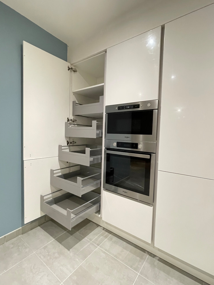This is an example of a large scandi u-shaped open plan kitchen with a submerged sink, wood splashback, integrated appliances, ceramic flooring, a breakfast bar and grey floors.
