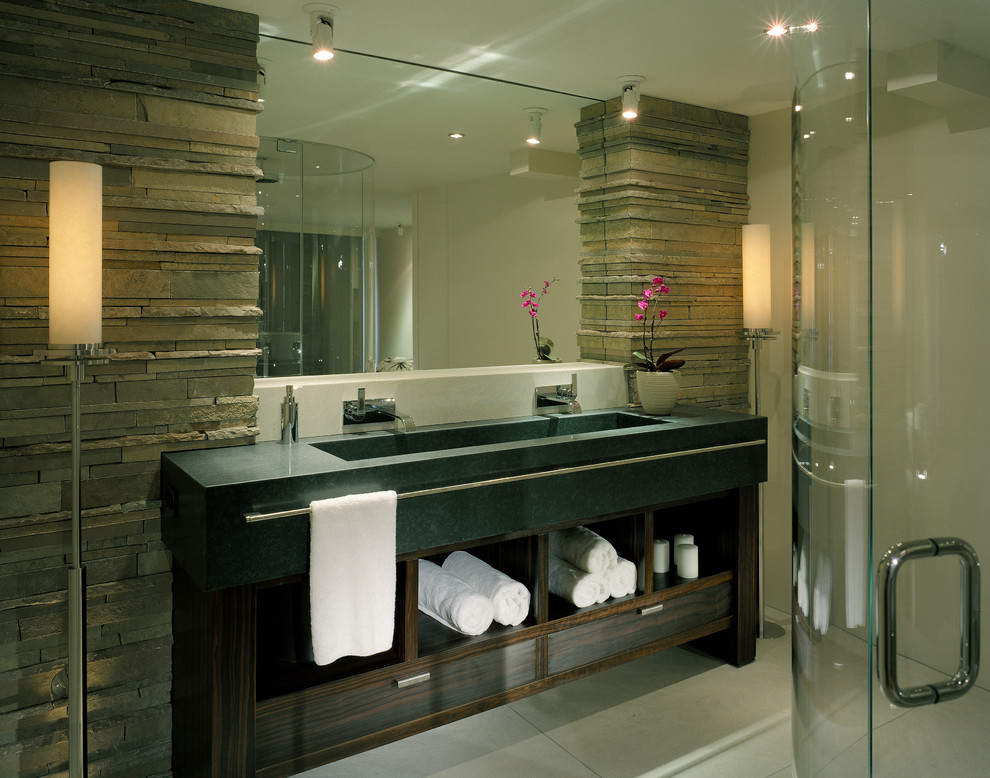Mid-sized contemporary master bathroom in Seattle with a trough sink, open cabinets, dark wood cabinets, a corner shower, gray tile, stone tile, grey walls, concrete floors, concrete benchtops, grey floor, a hinged shower door and grey benchtops.