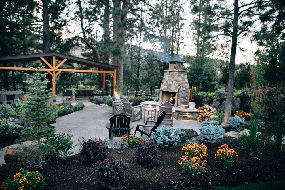 This is an example of a large arts and crafts backyard patio in Portland with natural stone pavers and a gazebo/cabana.