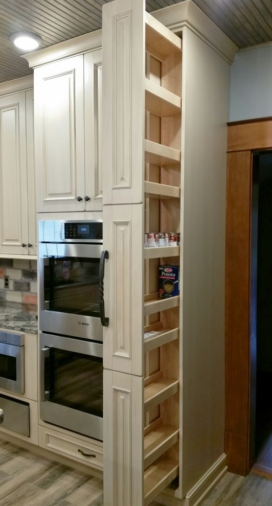 Inspiration for a large light wood floor kitchen remodel with raised-panel cabinets, white cabinets, quartzite countertops, multicolored backsplash, subway tile backsplash, stainless steel appliances and an island