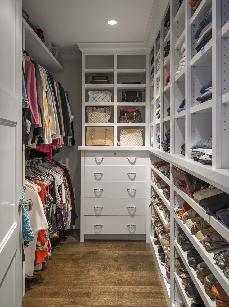 Inspiration for a mid-sized transitional women's medium tone wood floor walk-in closet remodel in Boston with flat-panel cabinets and white cabinets