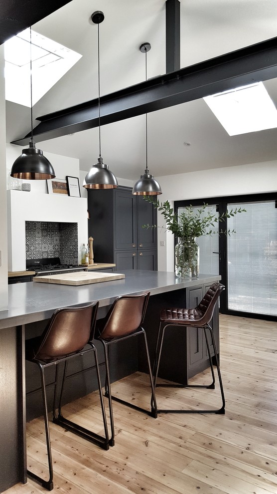 Transitional kitchen in Other with shaker cabinets, black cabinets, stainless steel benchtops, multi-coloured splashback, light hardwood floors, with island and beige floor.