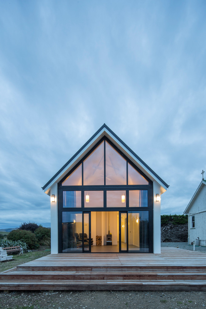 This is an example of a small contemporary one-storey concrete white exterior in Dunedin with a gable roof.