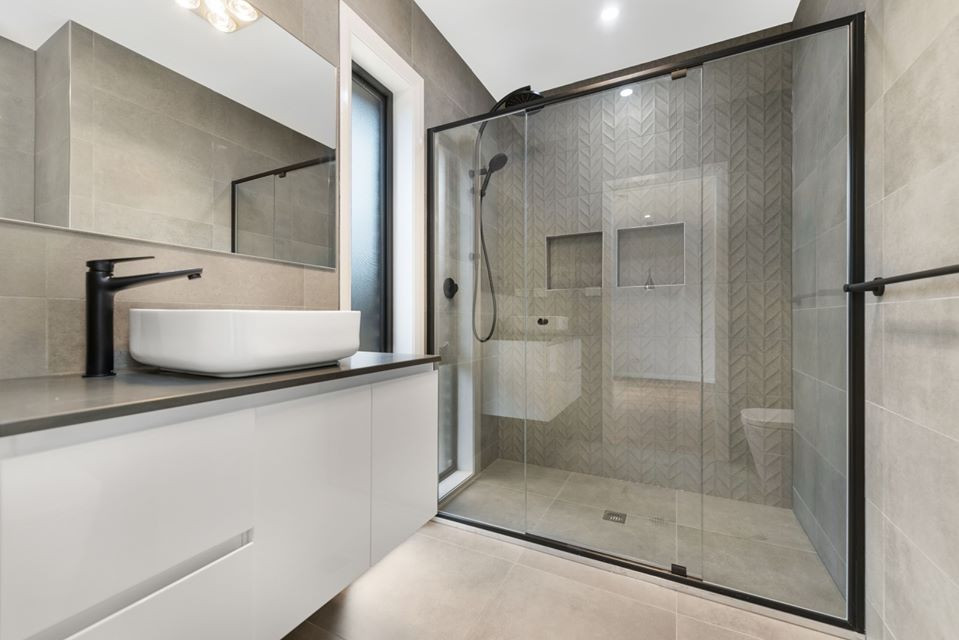 Idées déco pour une salle de bain moderne avec des portes de placard blanches, un carrelage gris, une vasque, un plan de toilette en marbre, un plan de toilette blanc, meuble simple vasque et meuble-lavabo suspendu.