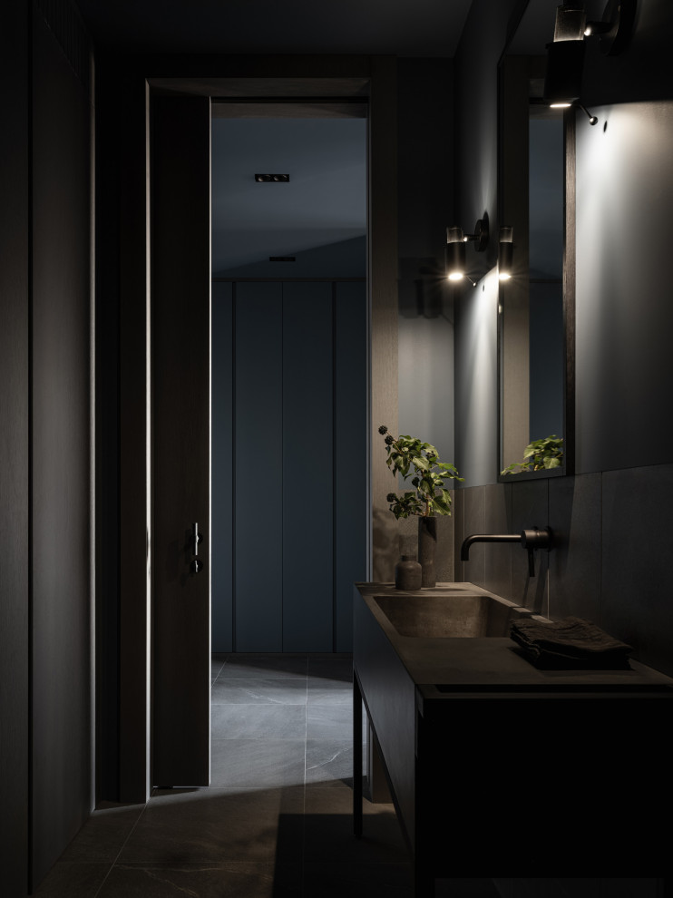 Идея дизайна: туалет среднего размера: освещение в стиле лофт с серыми фасадами, серой плиткой, серыми стенами, монолитной раковиной, серым полом, серой столешницей и напольной тумбой